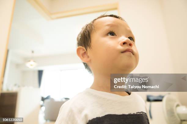 a boy looking up at something with a serious look - cute japanese boy stock-fotos und bilder