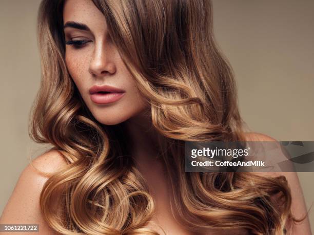 giovane bella modella con lunghi capelli ondulati ben curati - stile di capelli foto e immagini stock
