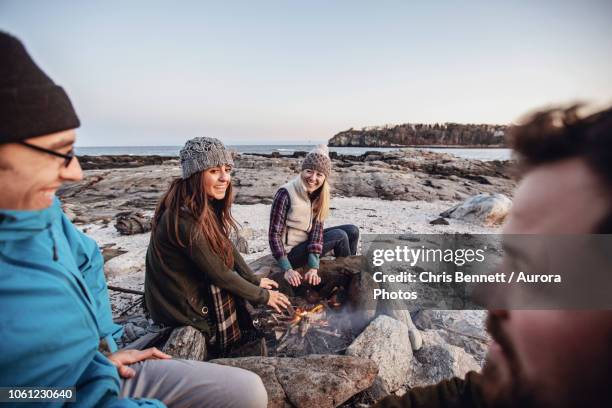 friends relaxing around campfire, portland, maine, usa - portland maine imagens e fotografias de stock