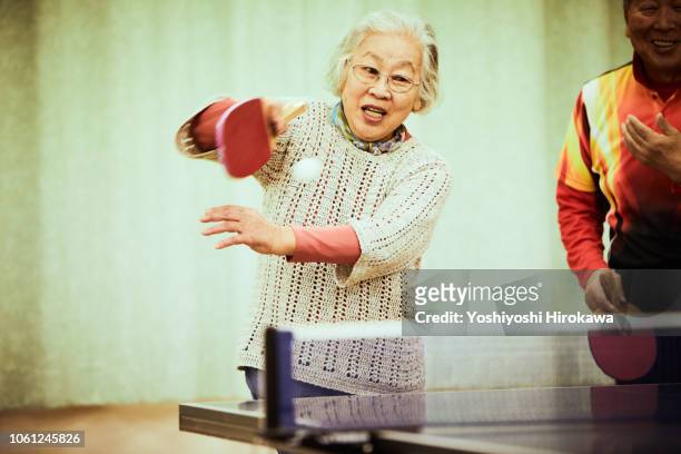 senior playing table tennis - women's table tennis stockfoto's en -beelden