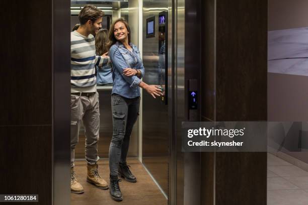 giovane coppia felice che parla tra loro in ascensore. - lift foto e immagini stock