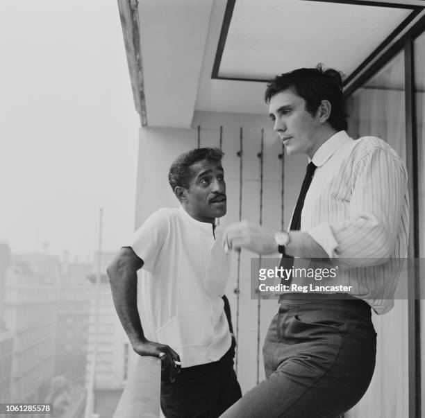 English actor Terence Stamp pictured on right with American singer and entertainer Sammy Davis Jr standing together on a hotel balcony in London on...