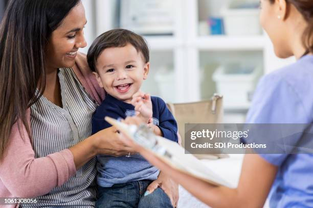 il bambino allegro gode della visita del pediatra - medical examination of young foto e immagini stock