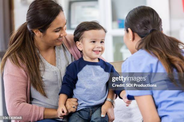 peuter jongen luistert naar attente kinderarts - op schoot stockfoto's en -beelden