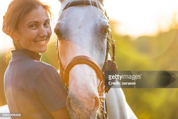 mujer abrazando a su caballo - 1 woman 1 horse fotografías e imágenes de stock