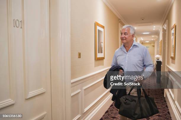 oudere man op weg naar de hotelkamer - hyatt hotels corp hotel ahead of earnings figures stockfoto's en -beelden