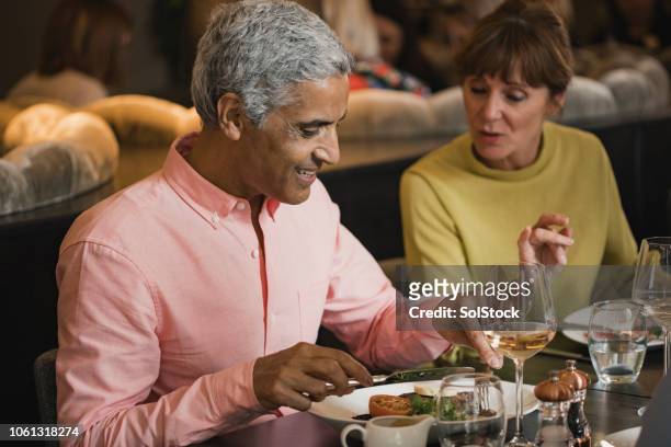 mature couple eating in restaurant - couple fine dining stock pictures, royalty-free photos & images