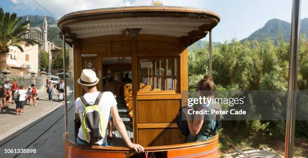 young couple sat at back of train going through town - palma majorca stock pictures, royalty-free photos & images