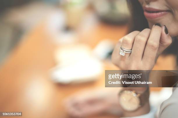 an engagement ring is a ring indicating that the person wearing it is engaged to be married - bridal shop stockfoto's en -beelden