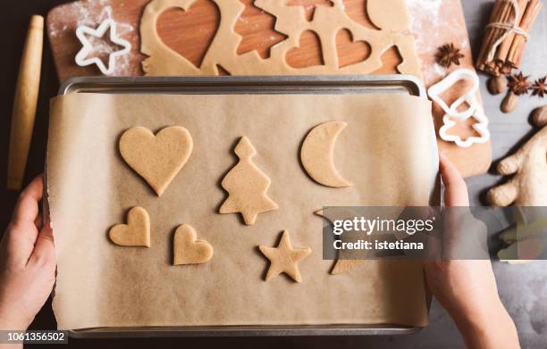 hands holding pan full of unbaked cookies - wachspapiere stock-fotos und bilder