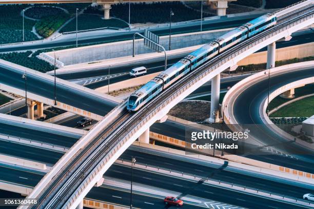 intersección de la autopista y trenes de metro en dubai, emiratos árabes unidos - built structure fotografías e imágenes de stock