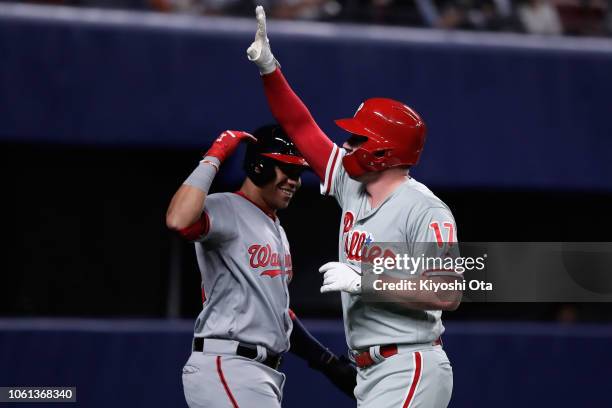 Designated hitter Rhys Hoskins of the Philadelphia Phillies celebrates hitting a two-run home run to make it 2-0 with Outfielder Juan Soto of the...