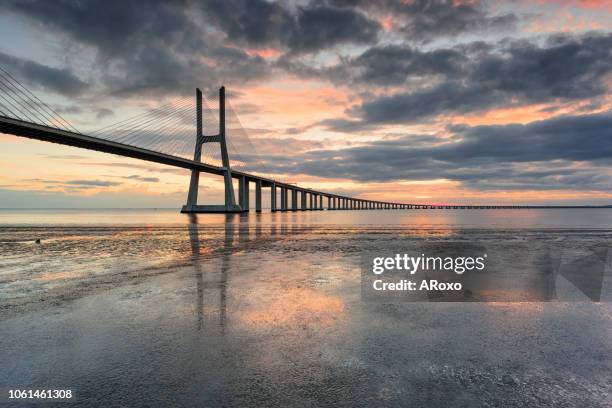 lisbon is an amazing tourist destination because its light, its monuments. portugal landmark. vasco da gama bridge landscape at sunrise - vasco da gama stock pictures, royalty-free photos & images