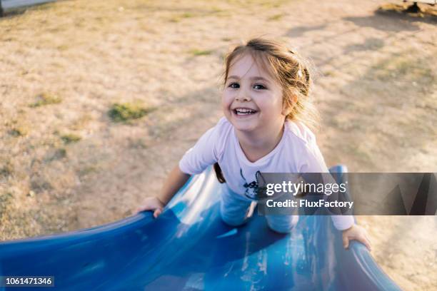 linda garota jogando no slide um playground - escorregador - fotografias e filmes do acervo