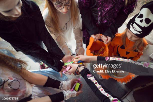 group of children trick or treating for sweets on halloween - halloween candy stock-fotos und bilder