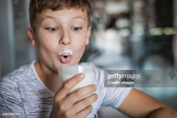 junge bei einem glas joghurt - milchbart stock-fotos und bilder