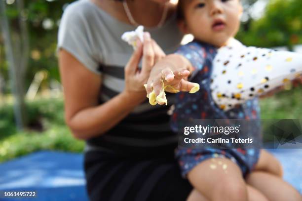 baby making a mess with cake icing at a birthday party - smash cake stock pictures, royalty-free photos & images