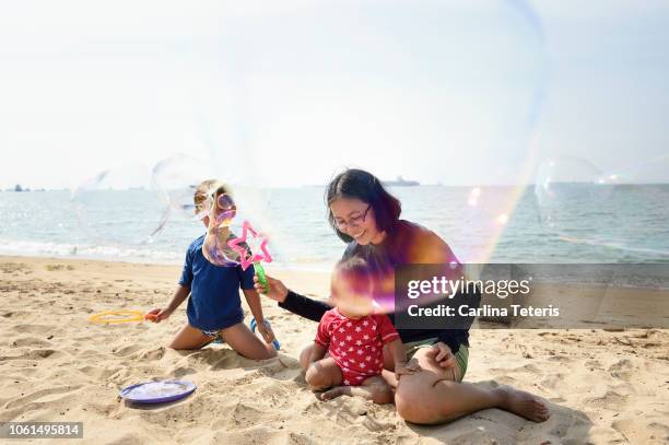 Family blowing bubbles on a beach