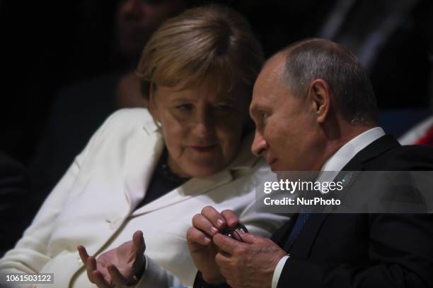 Russian President Vladimir Putin and German Chancellor Angela Merkel at the opening session of the Paris Peace Forum, an event that is a part of the...