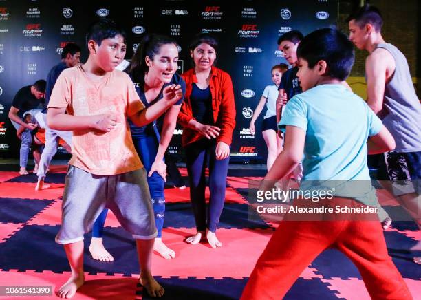 Flyweight Veronica Macedo gives instructions to children during partnership training sessions during the open workouts for fans and media at...