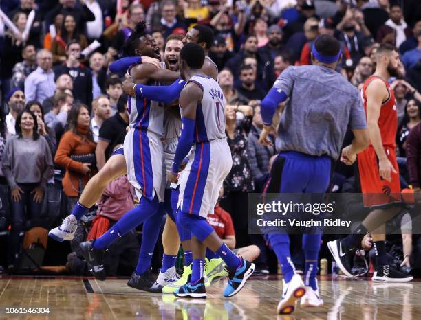 Reggie Bullock of the Detroit Pistons celebrates with teammates after sinking the winning basket during the second half of an NBA game against the...