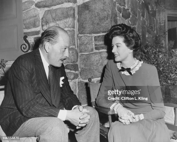 Jack Beddington , head of the film department at the British Ministry of Information, visits American actress Rosalind Russell on the set of 'Roughly...