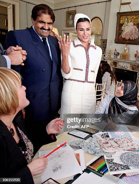 Qatar's emir, Sheikh Hamad bin Khalifa al-Thani and his wife Sheikha Mozah, talk to students during their visit to Clarence House in central London...