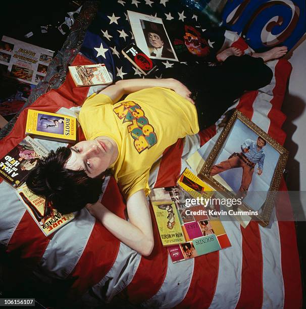 Singer and songwriter Bobby Gillespie of Scottish rock group Primal Scream, lying on a bed surrounded by paraphernalia, 17th September 1991. He is...