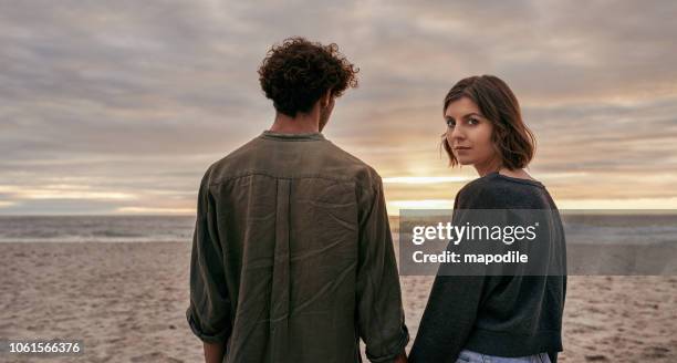 we're off to find our sunset - woman looking over shoulder serious stock pictures, royalty-free photos & images