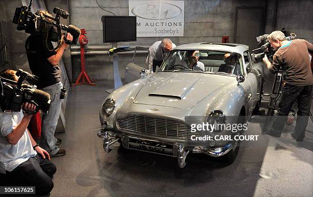 Television crews film a 1964 Aston Martin DB5 vehicle used by British actor Sean Connery when he played fictional spy James Bond in the films...