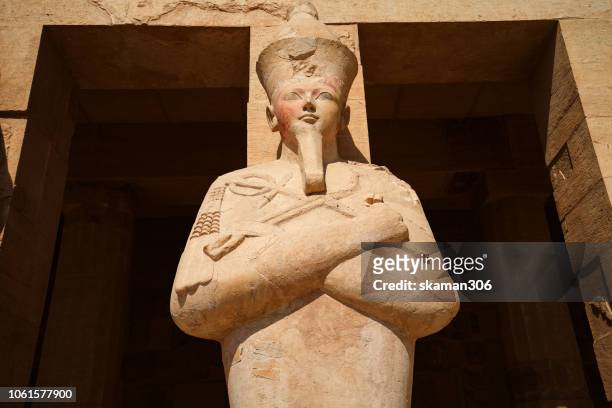 statue of pharaoh hatshepsut dress up like osiris at hatshepsut temple deir el-bahari near luxor (thebes) egypt - piramide van chefren stockfoto's en -beelden
