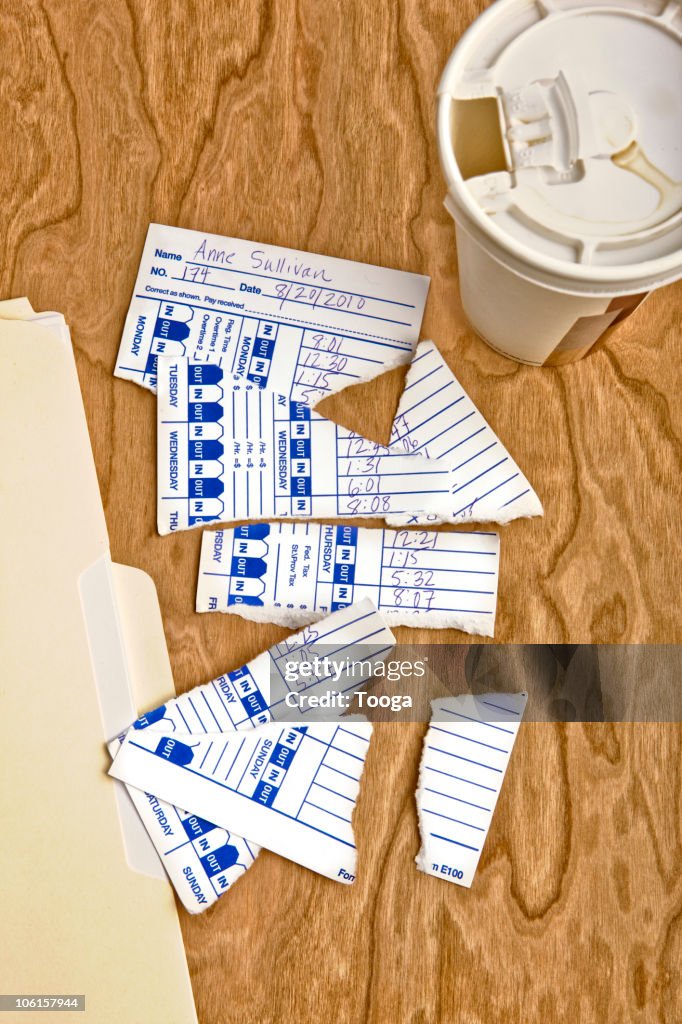Torn time card and empty to go coffee