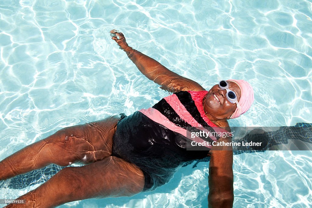 Senior woman floating on her back in the pool