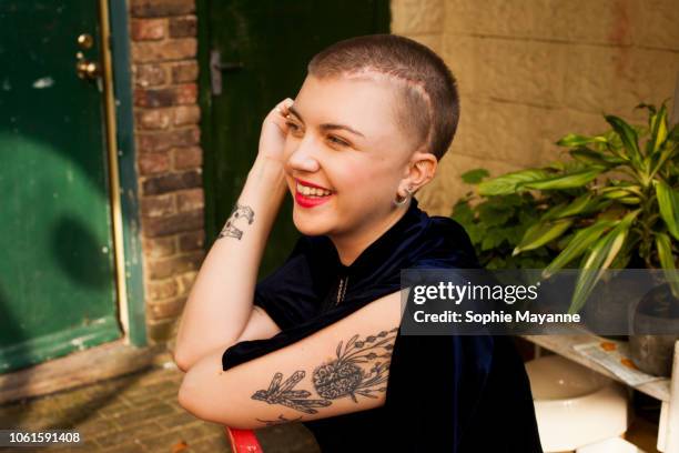 a young woman leaning on a chair laughing - mark stock pictures, royalty-free photos & images