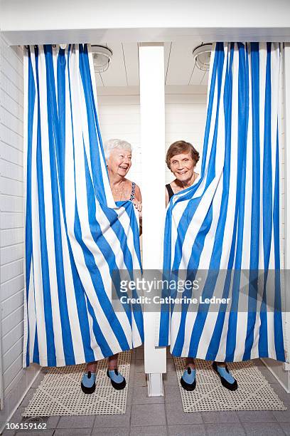 senior women clutching shower curtains - senioren in bad stock-fotos und bilder