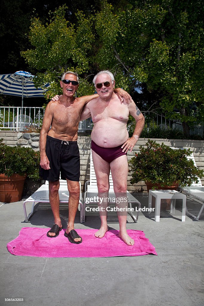 Two senior men in bathing suits laughing