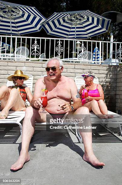 seniors enjoying drinks by the pool - old woman in swimsuit imagens e fotografias de stock