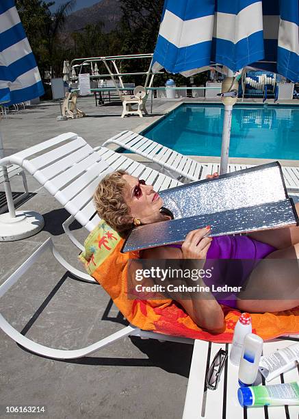 portrait of senior woman tanning her face. - the tanning of america stock pictures, royalty-free photos & images