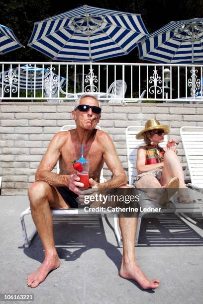 senior couple sunbathing and enjoying drinks - richesse photos et images de collection