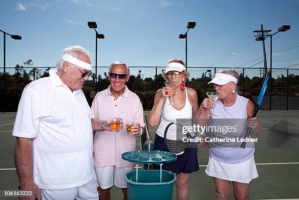 seniors drinking on the tennis court - spirituosen stock-fotos und bilder