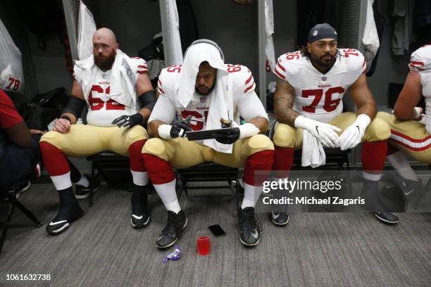Erik Magnuson, Joshua Garnett and Garry Gilliam of the San Francisco 49ers sit in the locker room prior to the game against the Arizona Cardinals at...