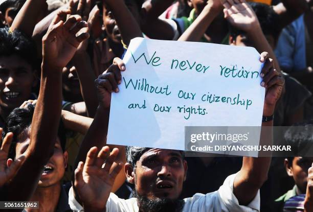 Rohingya refugee carries a placard that says "We never return" at a protest against a disputed repatriation programme at the Unchiprang refugee camp...