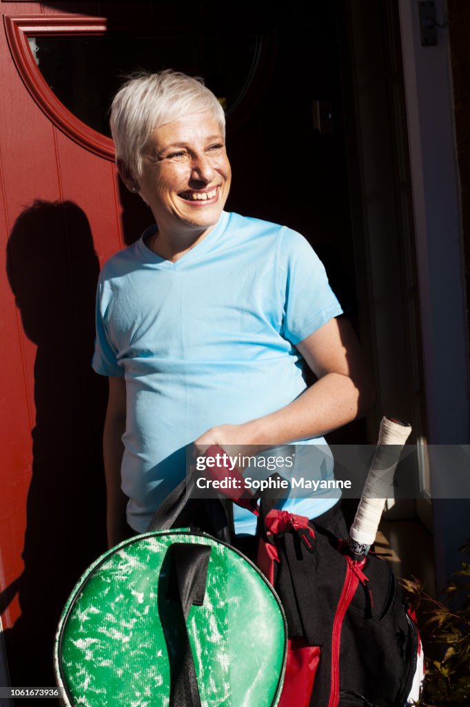 A mature woman leaving a house in sports wear