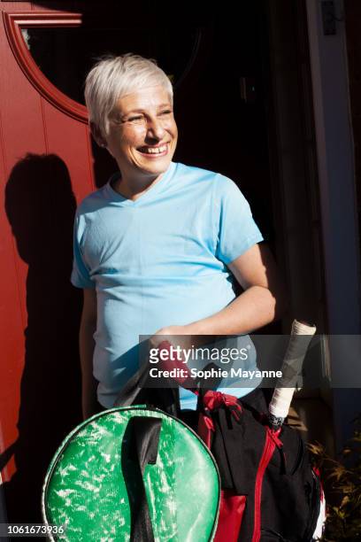 A mature woman leaving a house in sports wear