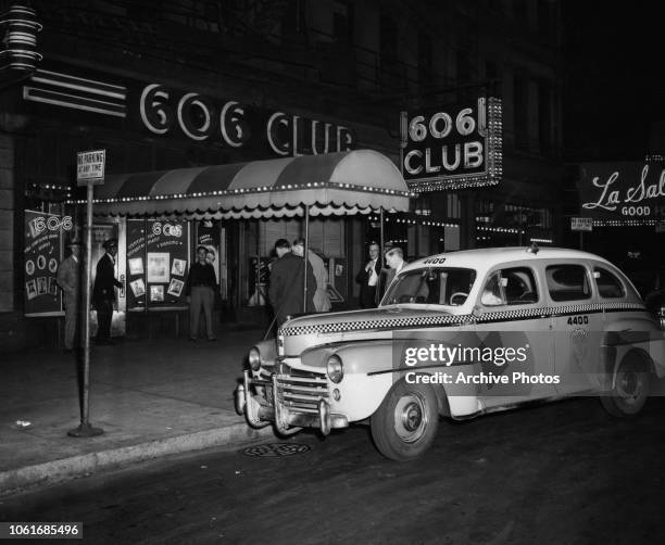 Group of men arrive by Checker Taxi at the 606 Club, a burlesque club at 606 South Wabash Avenue, Chicago, Illinois, 1952. Performer Carrie Finnell...