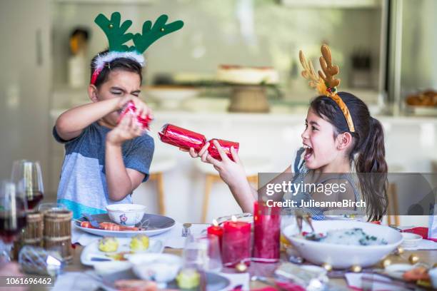 australische kinder zu hause ziehen christmas cracker am tisch - christmas australia stock-fotos und bilder