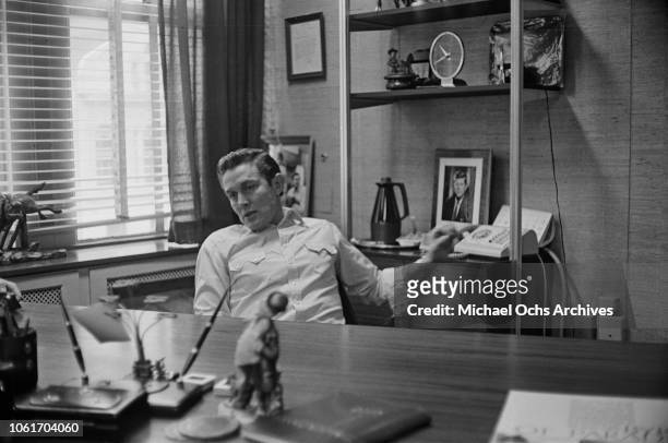 American country music singer and television host Jimmy Dean in his office, USA, November 1964. He is being interviewed by Jim Delehant for 'Country...