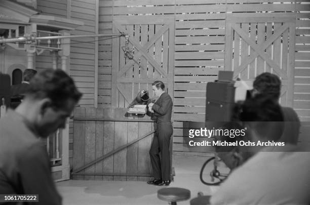 American country music singer and television host Jimmy Dean talks to Rowlf the Dog on the set of 'The Jimmy Dean Show', USA, 13th November 1964....