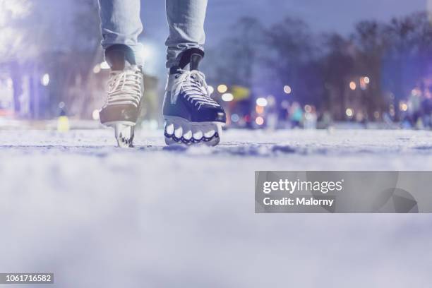 close-up of feet with ice skates on frozen lake. bokeh in the background. winter. - eislaufen stock-fotos und bilder