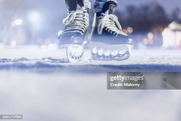 close-up of feet and ice skates on frozen lake. ice hockey. - outdoor ice hockey stock pictures, royalty-free photos & images